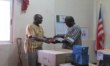 Liberia’s Information Minister receives audio equipment from HC3’s Teah Doegmah.