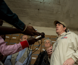 USAID officielle interviewé par des journalistes locaux sur son initiative avec le Paul G. Allen Family Foundation pour fournir 9,000 kits de protection des ménages dans le cadre de la réponse à aider les Libériens combattre le virus Ebola. Chaque kit comprend des sacs de risque biologique, savon, EPI, et des gants. Photo par Morgane Wingard