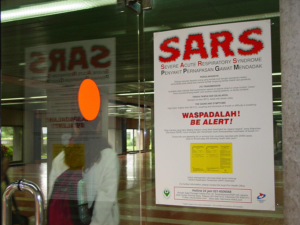 A poster warns travelers about Severe Acute Respiratory Syndrome (SARS) at Soekarno Hatta International airport in Jakarta, Indonesia. The poster was produced by the Johns Hopkins Bloomberg School of Public Health/Center for Communication Programs, as part of the KUIS and STARH projects. © 2004 Catherine Harbour, Courtesy of Photoshare