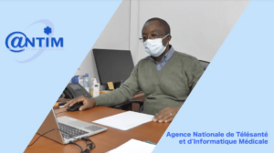 A man in Mali wearing a mask and working on a laptop. The text reads: "Agence Nationale de Télésanté et d'Informatique Médicale"